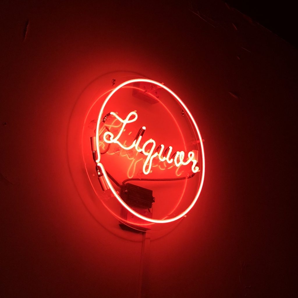 An illuminated neon sign that says "liquor".