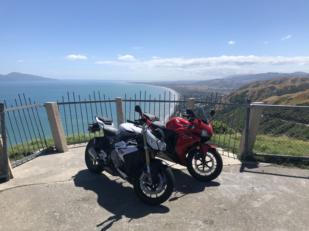 BMW S1000R and Honda CBR500R motorcycles parked at an overlook on the Paekakariki road.